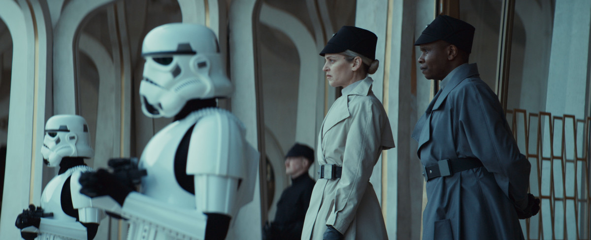 Andor-sarjan päähenkilöt seisovat rakennuksen edessä ja Stormtroopereiden vieressä (© Lucasfilm Ltd)