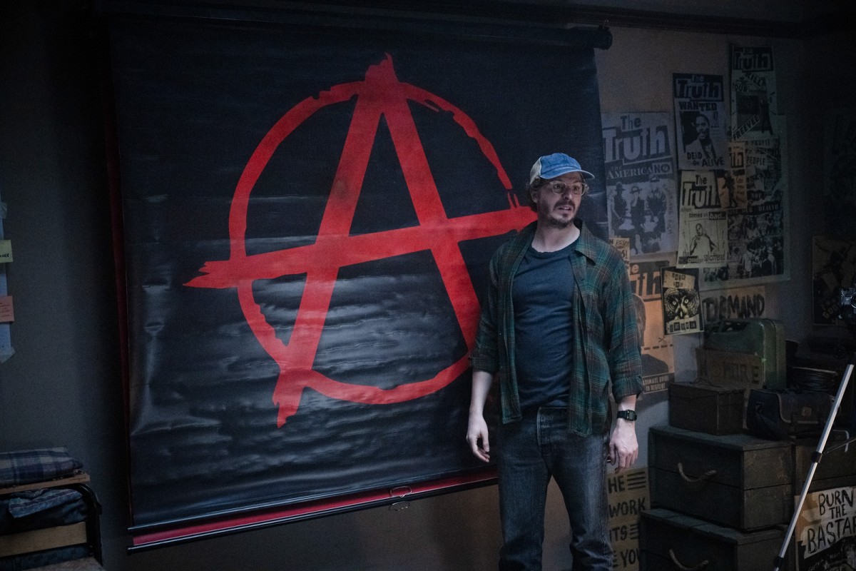 Michael Cera anarkistijulisteen edessä The Running Man -elokuvassa ( © Paramount Pictures)