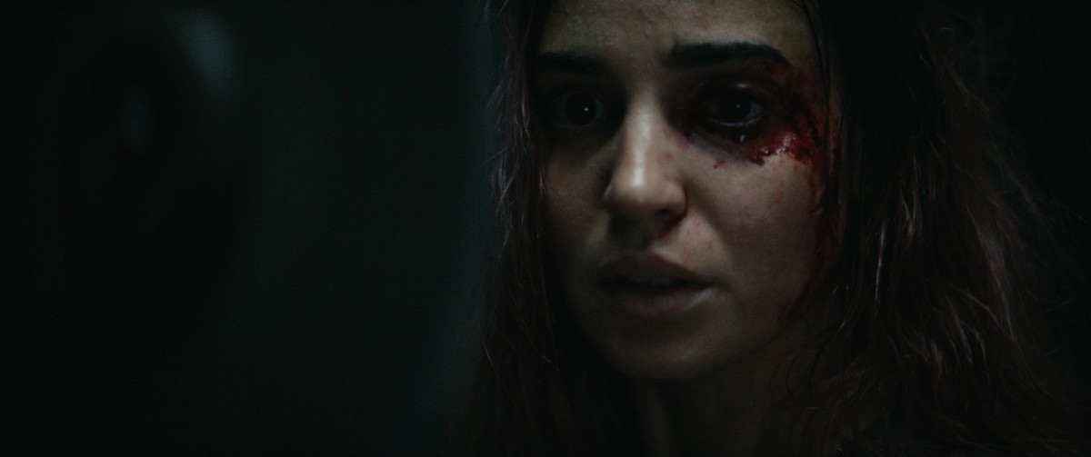 Souheila Yacoub katsoo tummunein silmin kohti kameraa elokuvassa Evil Dead Burn (@ Warner Bros. Entertainment)