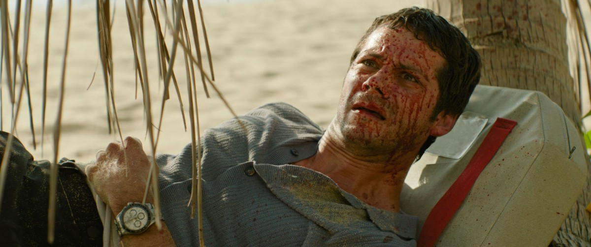 Dylan O'Brien makaa verisenä rannalla elokuvassa Send Help (© 20th Century Studios)