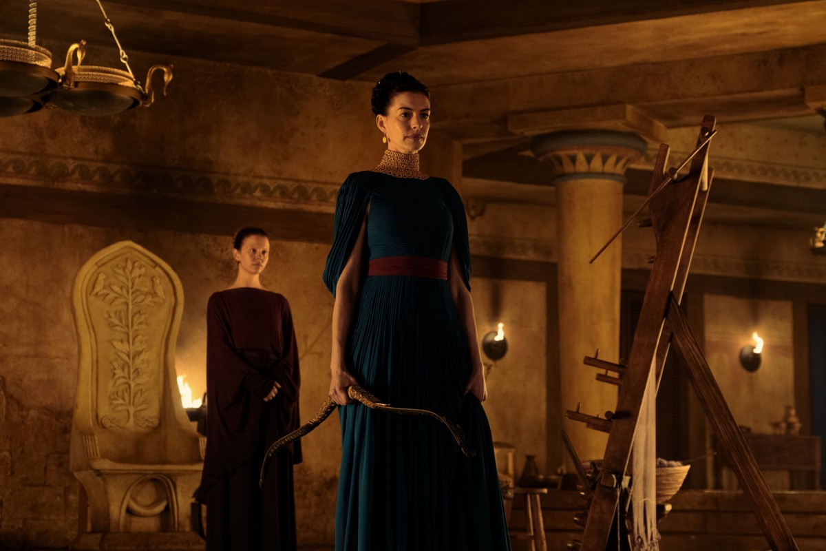 Anne Hathawayn esittämä Penelope seisoo huoneessa jousipyssy kädessä elokuvassa The Odyssey (@ Universal Studios)